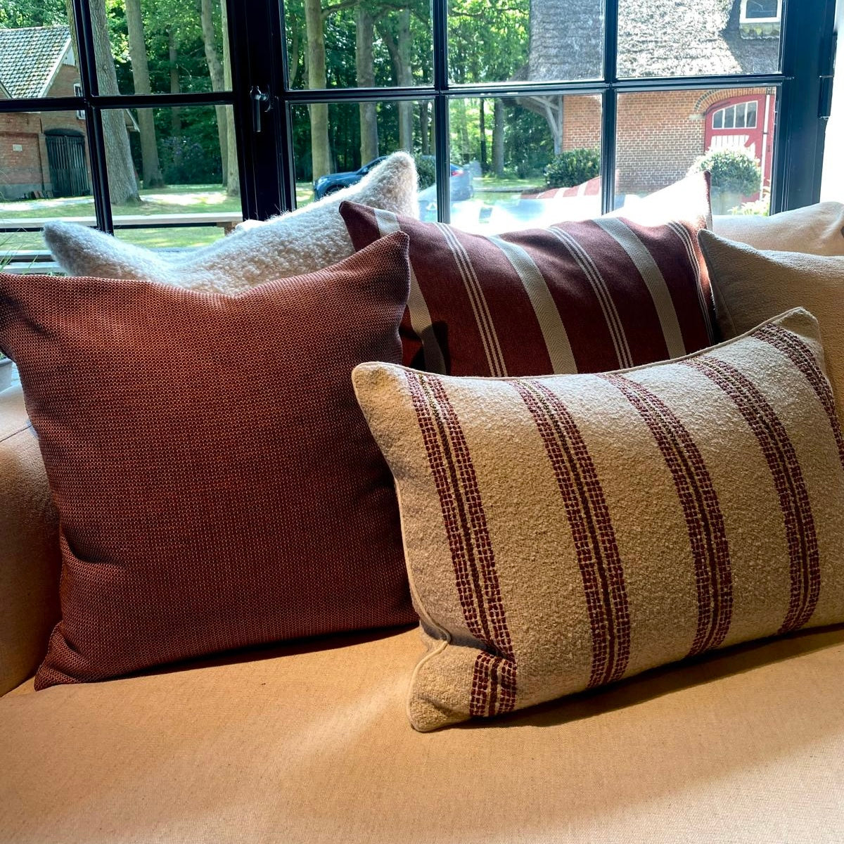 Scapa Home outdoor cushions in terracotta on sofa